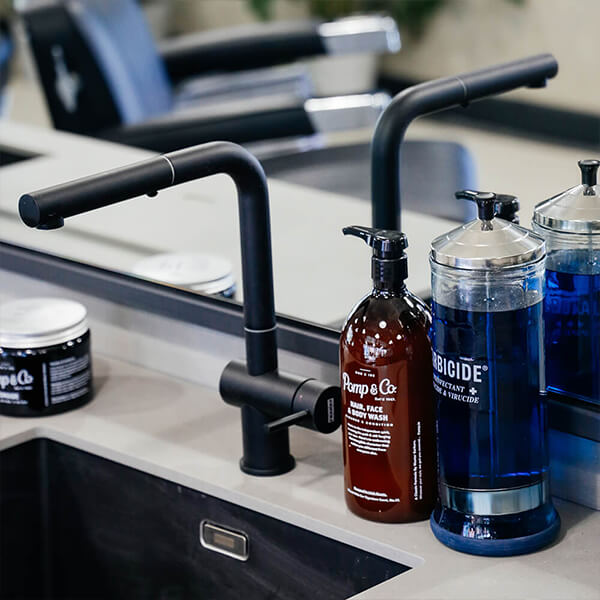 Pomp & Co. Wash på 1 liter står på bord i barbershop.